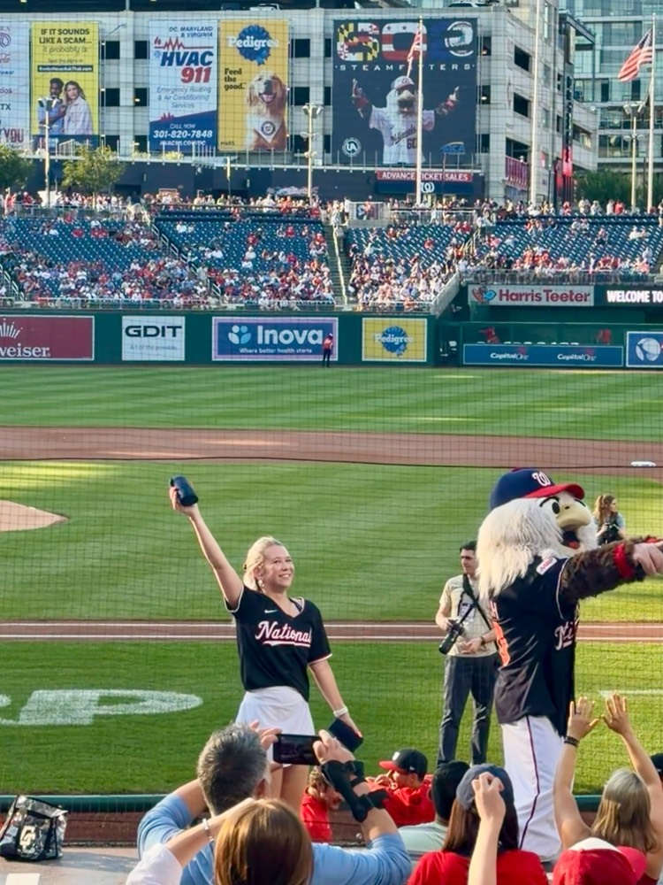 Ieva on top of the dugout with Screech, the Nationals mascot