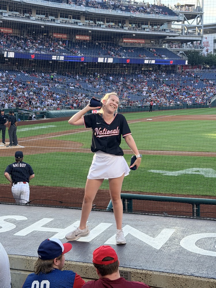 Ieva mid-throw during the t-shirt toss, crowd behind her