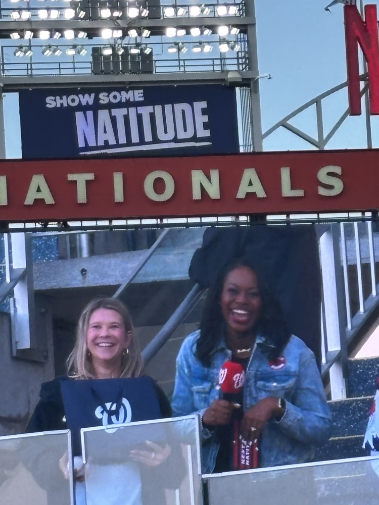 Ieva and a friend under a Nationals sign at the park